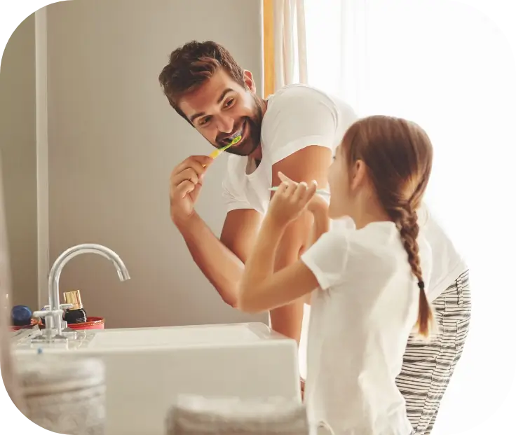 Father and daughter brushing their teeth together