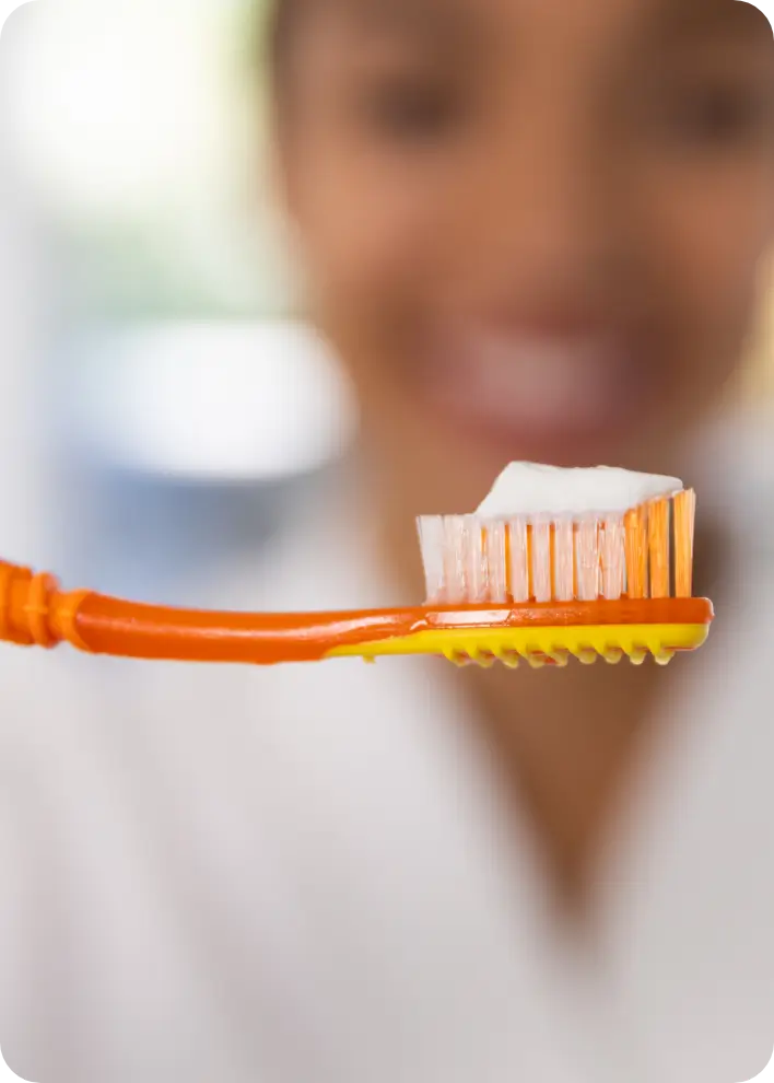 Woman holding a toothbrush with toothpaste on it