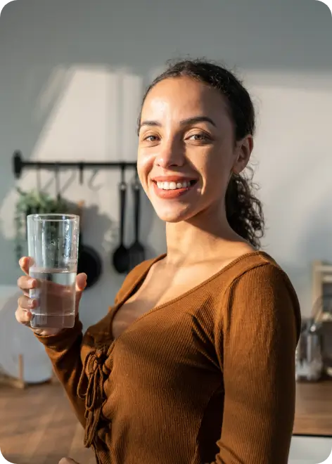 Smiling woman holding glass of water